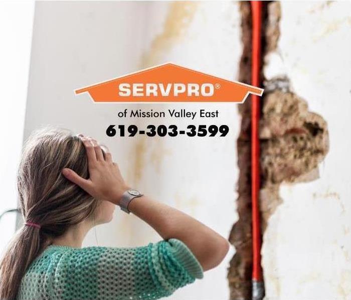 women staring at property damage in a home 