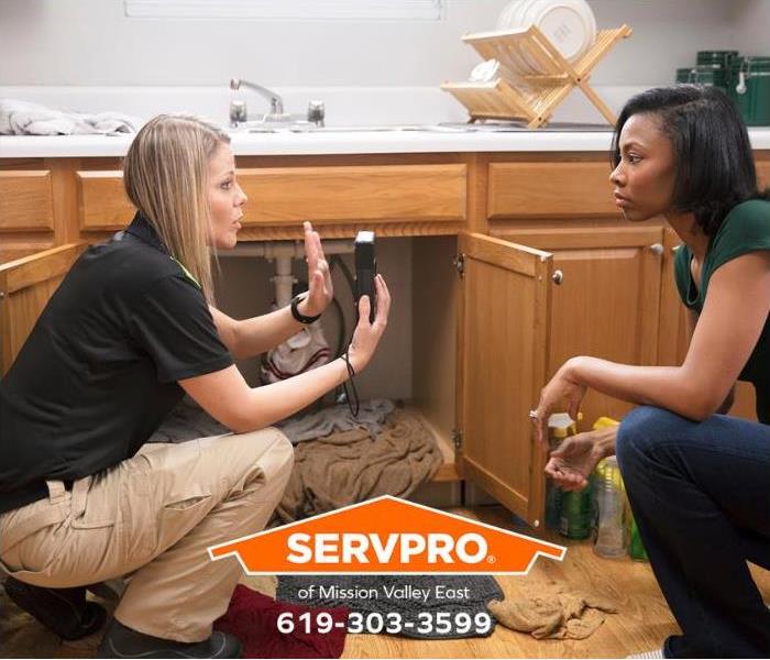 A SERVPRO technician explains a hygrometer reading to a customer.