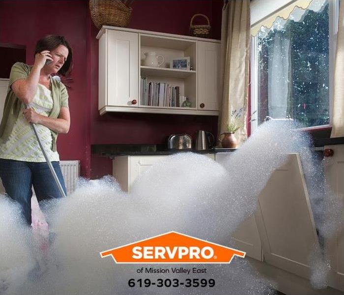 A person calls for help while watching the dishwasher flood the kitchen.