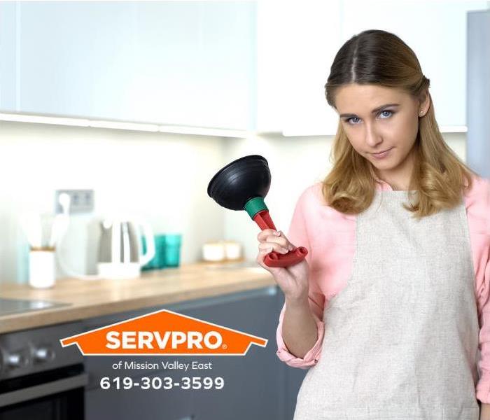 A homeowner is holding a sink plunger.