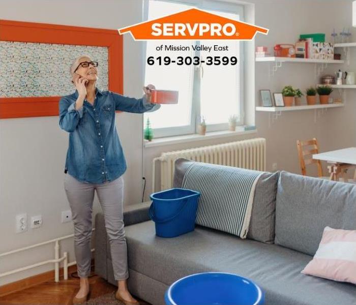 A person calls for help while holding a pot to catch the water drops.