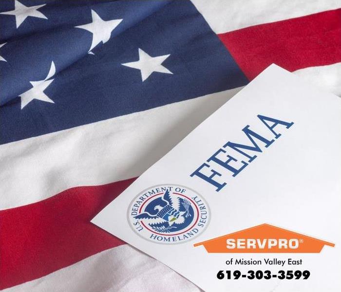 The letters FEMA on an official U.S. Department of Homeland Security form laid on an American flag.